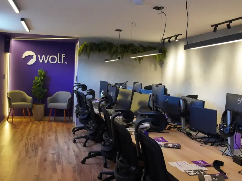Escritório Wolf Aceleradora em Caruaru — vista panorâmica com estações de trabalho e parede com logo