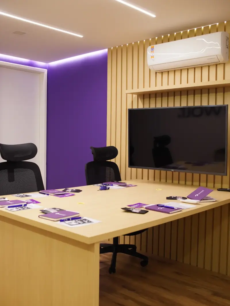 Sala de reunião do escritório Wolf com mesa, TV e iluminação ambiente
